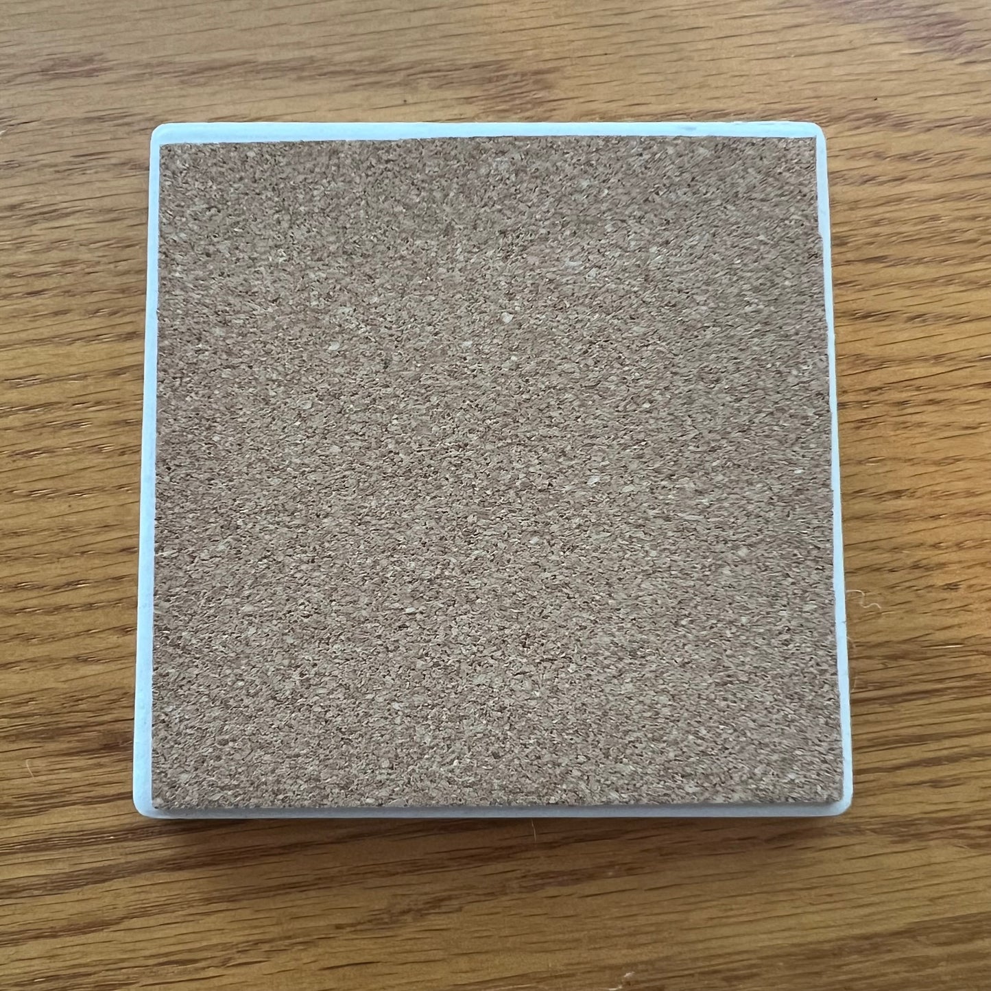 Eclectic Spruce's ceramic coasters have a cork backing to protect your furniture. This photo shows the cork backside of one coaster.