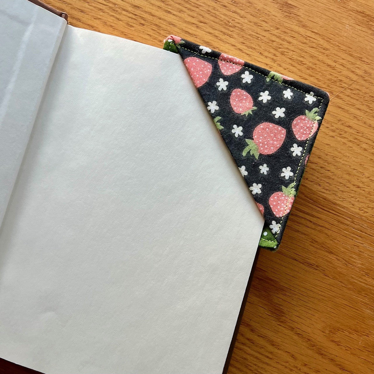 Eclectic Spruce corner bookmark placed inside of a book.