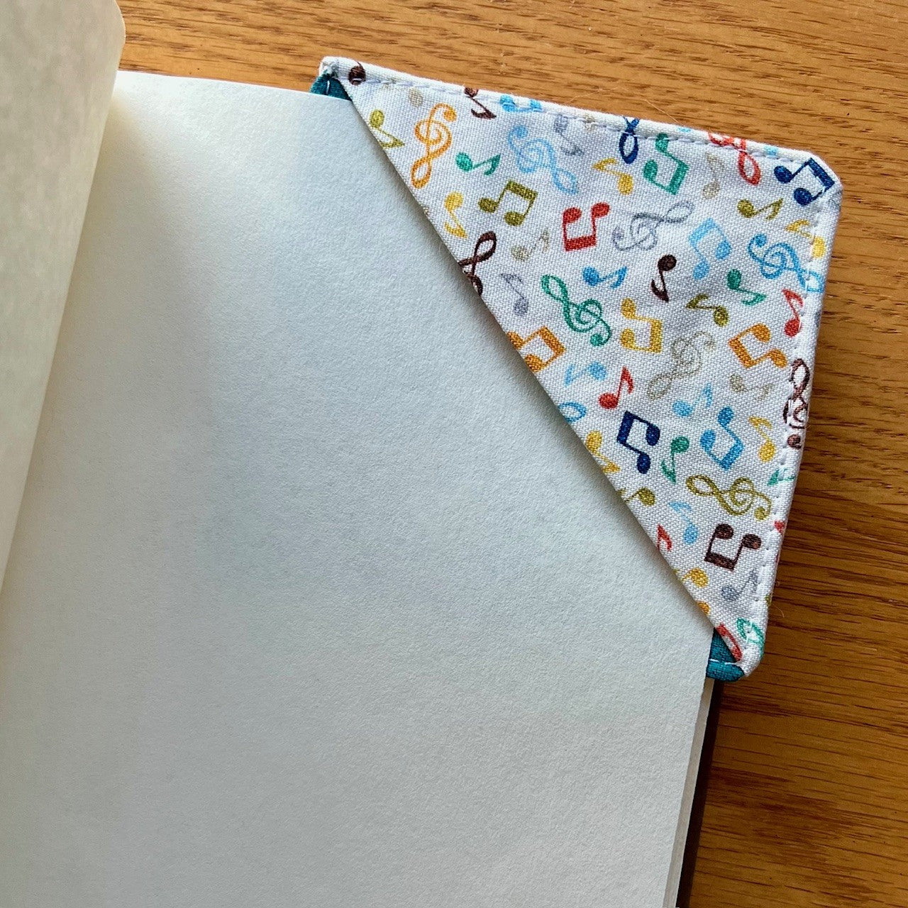 Eclectic Spruce corner bookmark placed inside of a book.