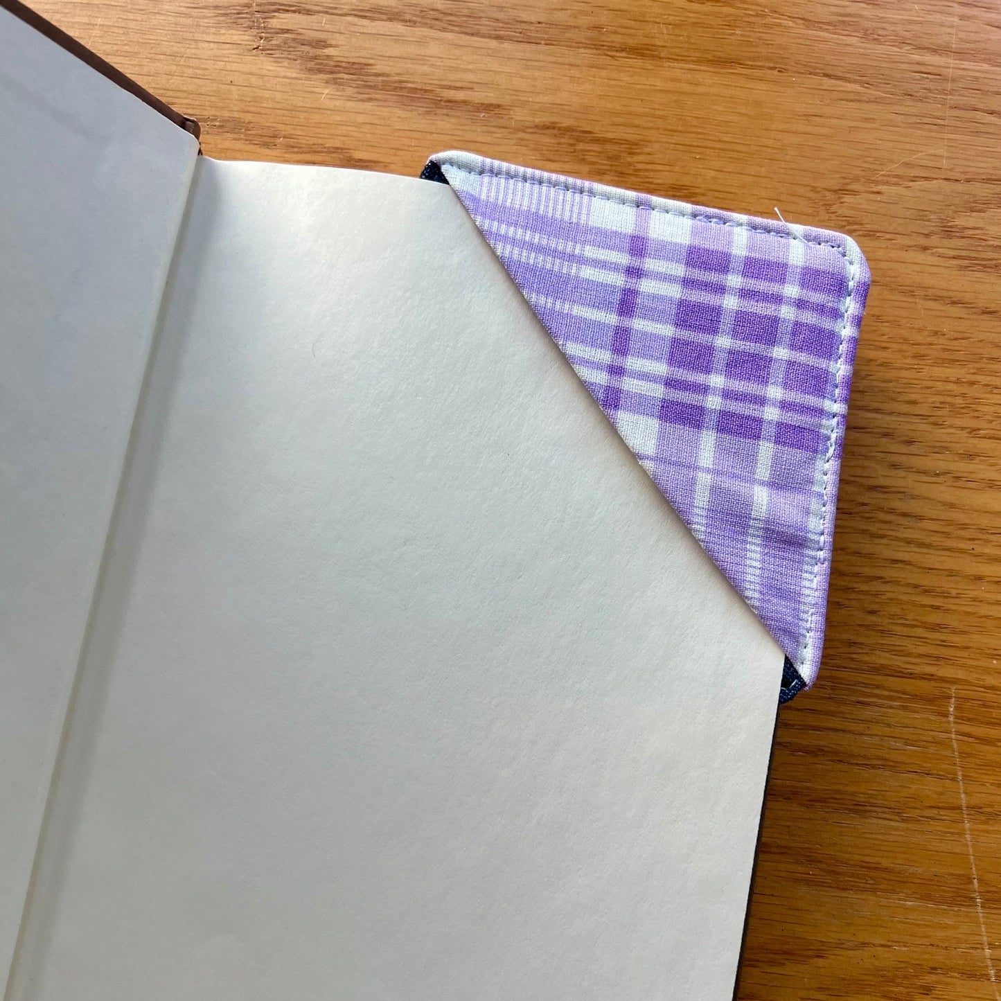 Eclectic Spruce corner bookmark placed inside of a book.