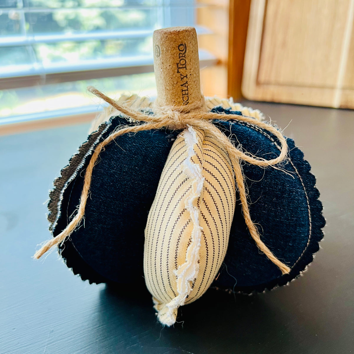 Pumpkin 6: Handmade Eclectic Spruce medium sized pumpkin with sculptural lobed design made with dark denim, ticking stripe fabric, weighted base, and wine cork and twine wrapped stem.