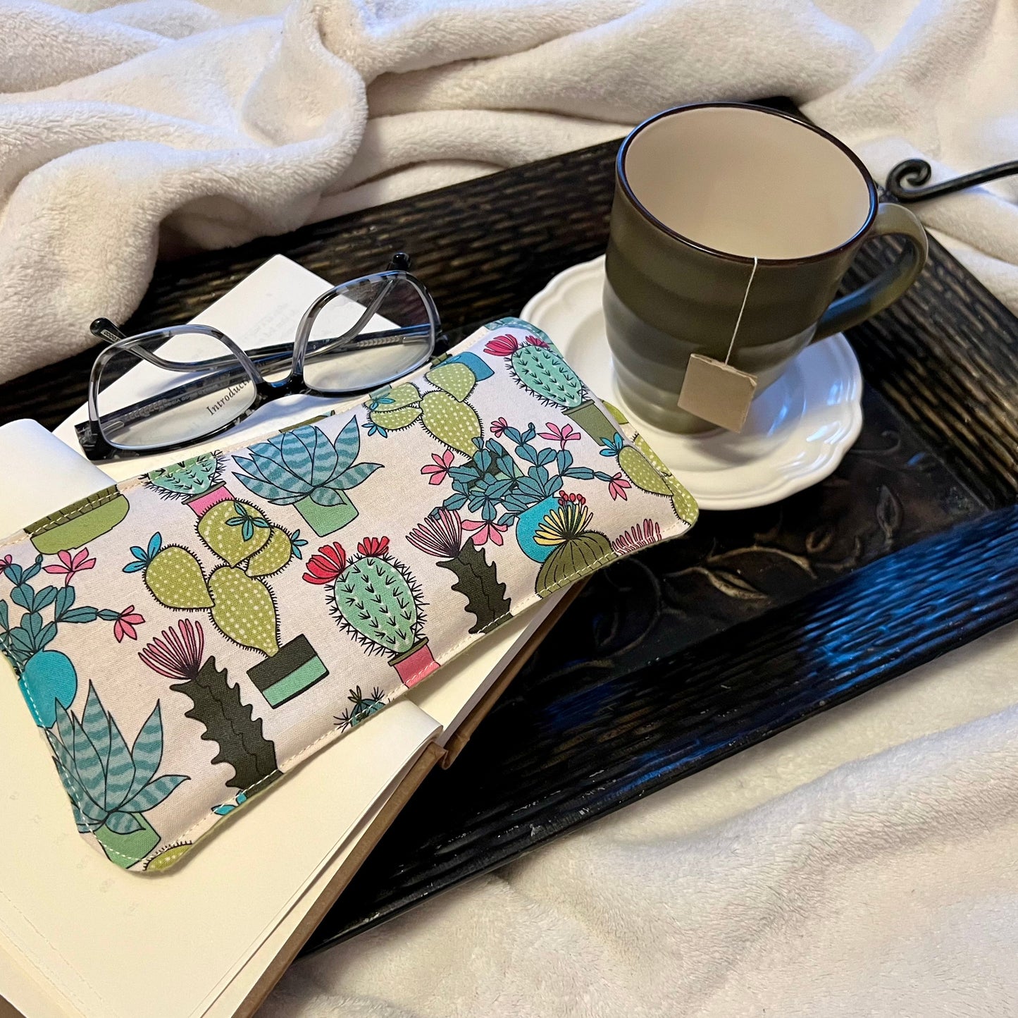Tray with book, Weighted Eye Pillow, and mug on a soft blanket