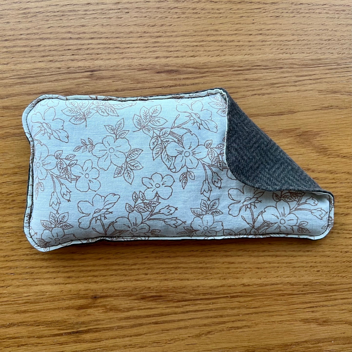 Dual-sided Weighted Eye Pillow with cream fabric and brown flower sketched pattern on the cotton side and brown herringbone pattern on the flannel side.
