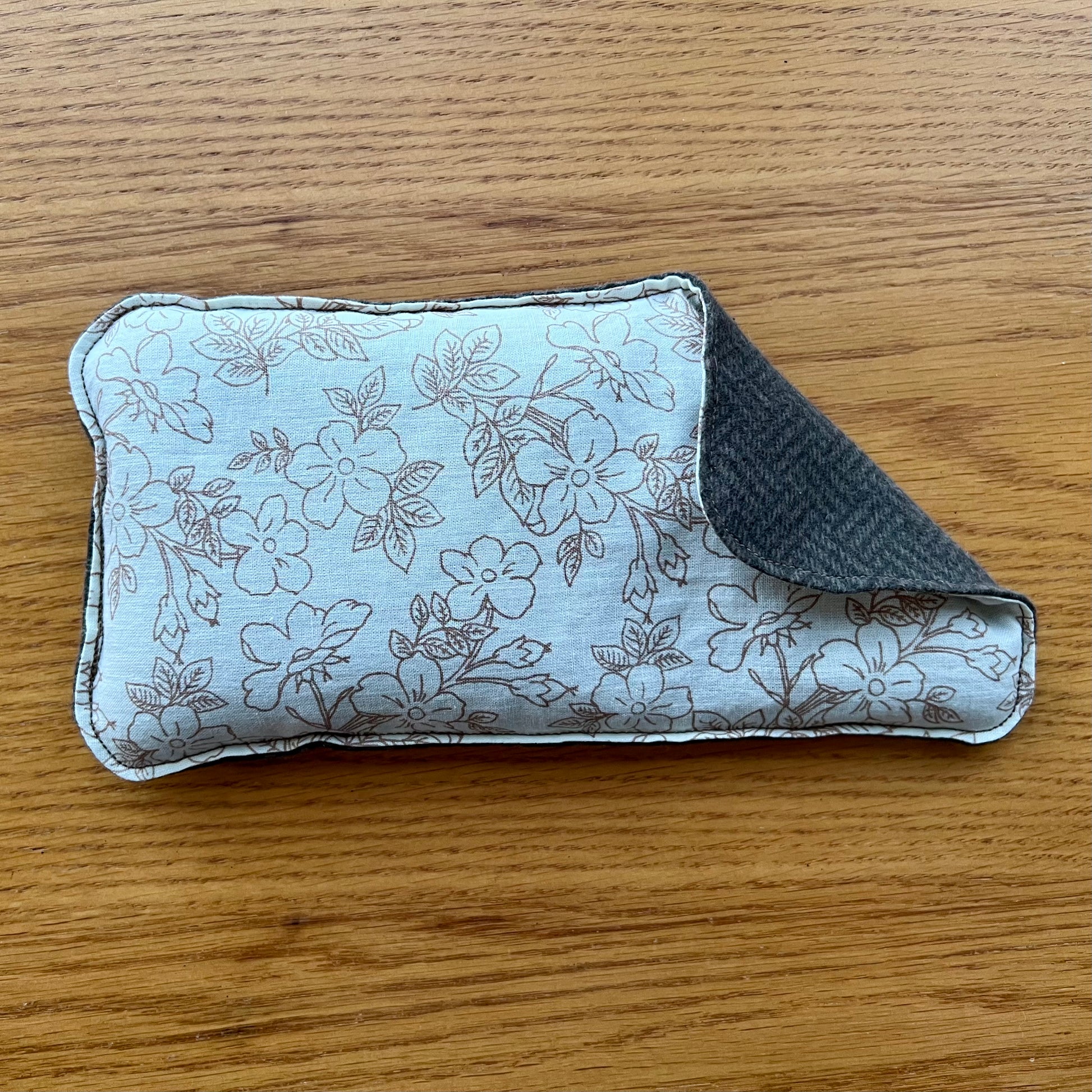 Dual-sided Weighted Eye Pillow with cream fabric and brown flower sketched pattern on the cotton side and brown herringbone pattern on the flannel side.