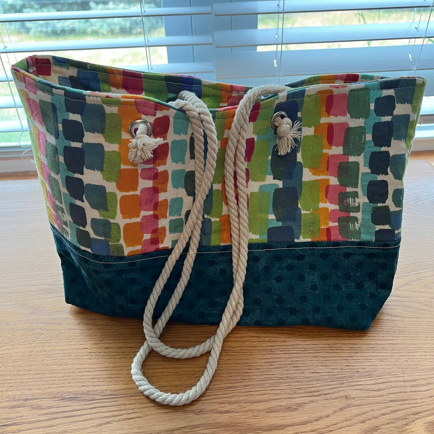 Eclectic Spruce handmade rope-handled tote bag - a large tote bag with a colorful geometric pattern on the upper half and a teal polka dot lower half.