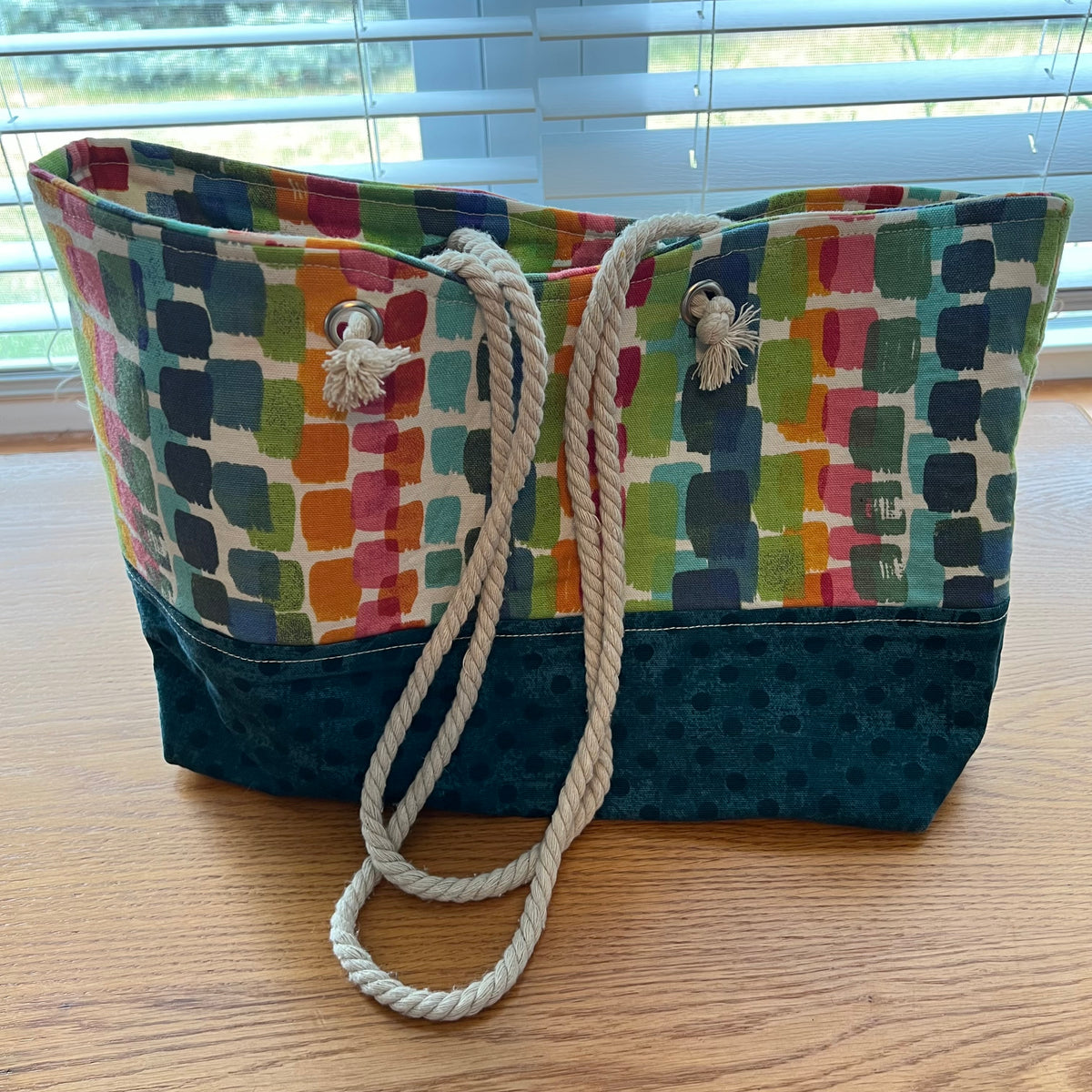 Eclectic Spruce handmade rope-handled tote bag - a large tote bag with a colorful geometric pattern on the upper half and a teal polka dot lower half.