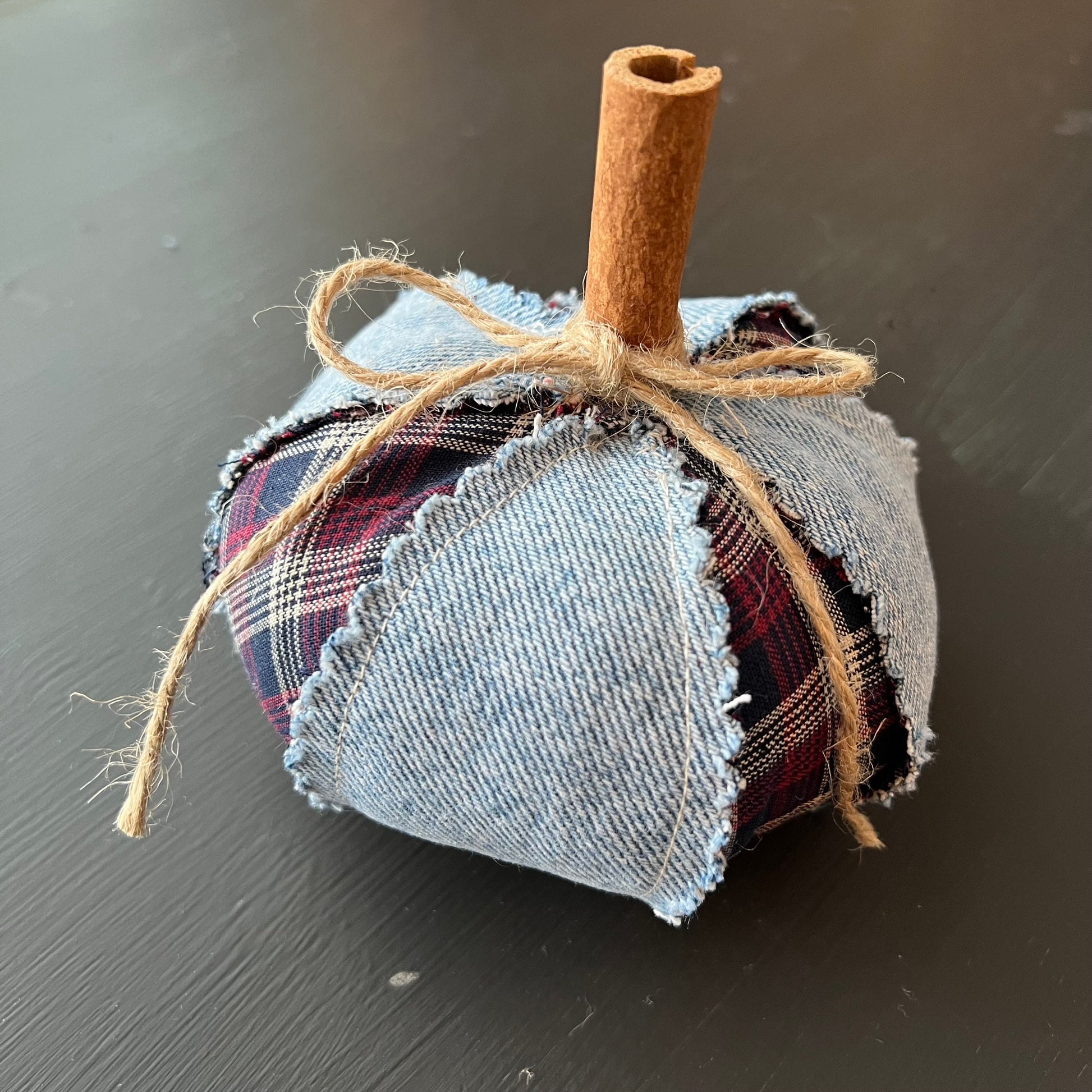 Pumpkin 1: Handmade Eclectic Spruce small pumpkin made with alternating denim and plaid fabric panels with raw seams, accented with real cinnamon stick stem and twine bow.