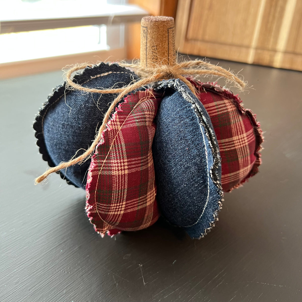Pumpkin 7: Handmade Eclectic Spruce medium sized pumpkin with sculptural lobed design made with dark denim, warm red plaid fabric, weighted base, and wine cork and twine wrapped stem.