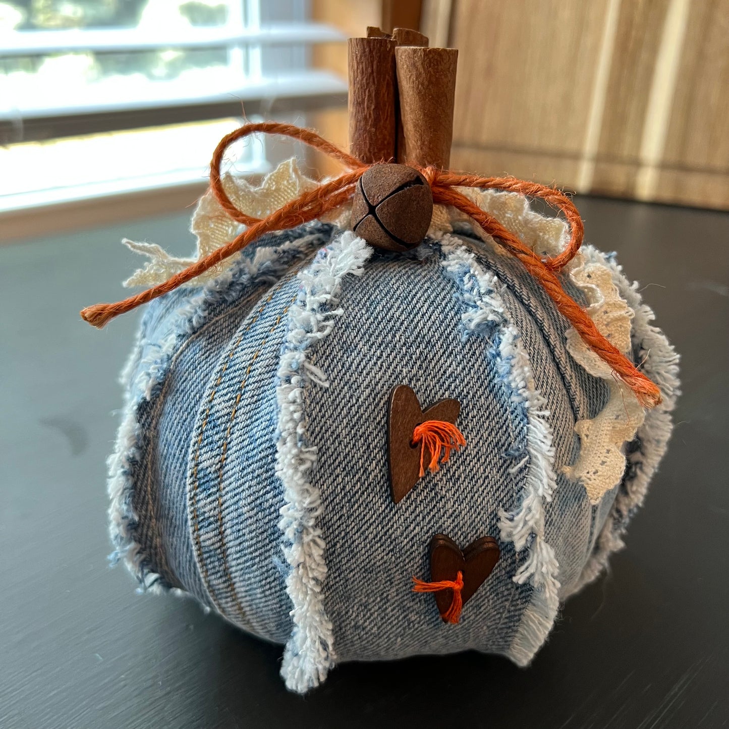 Pumpkin 4: Handmade Eclectic Spruce medium pumpkin made with frayed Denim fabric and real cinnamon stick stem, accented with charming wood heart buttons, rusty jingle bell, and lace/twine bow.