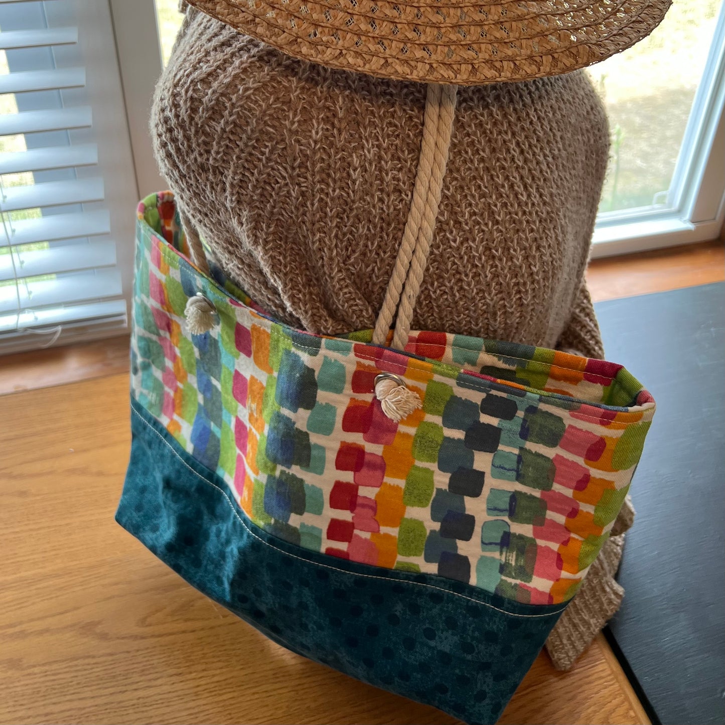 Eclectic Spruce handmade rope-handled tote bag - a large tote bag with a colorful geometric pattern on the upper half and a teal polka dot lower half.