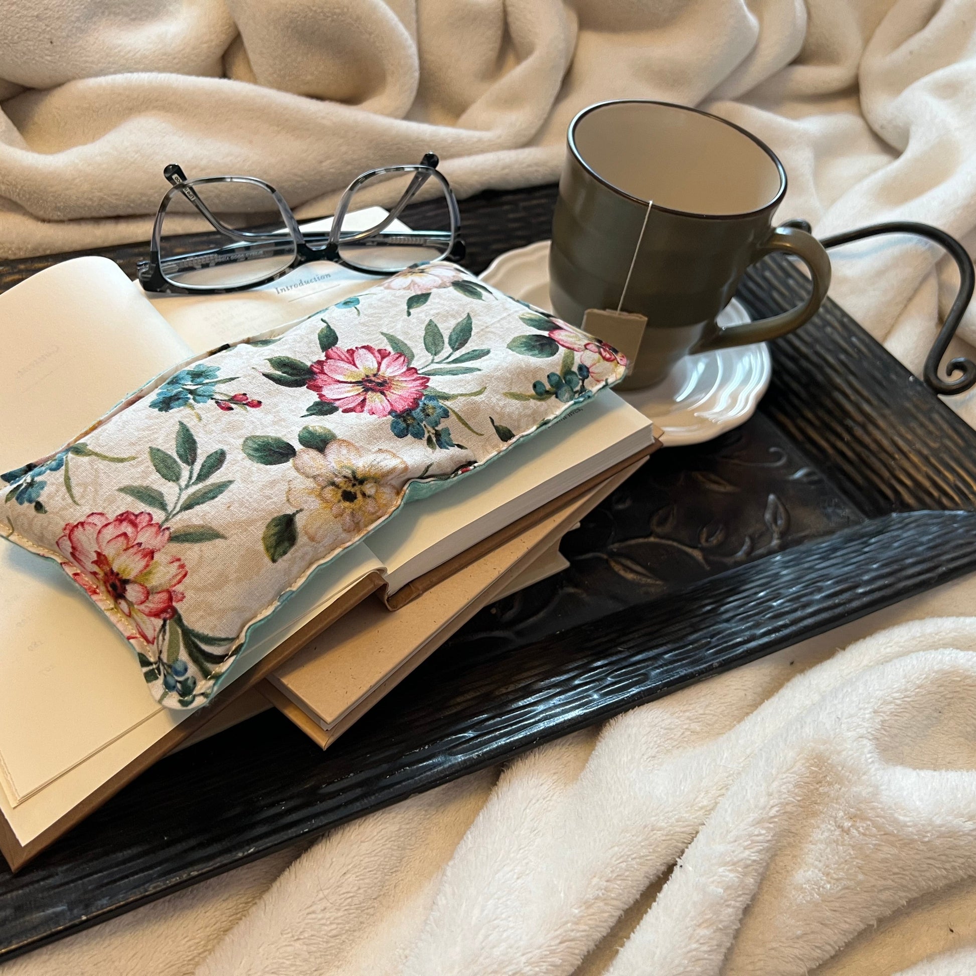 Tray with book, Weighted Eye Pillow, and mug on a soft blanket