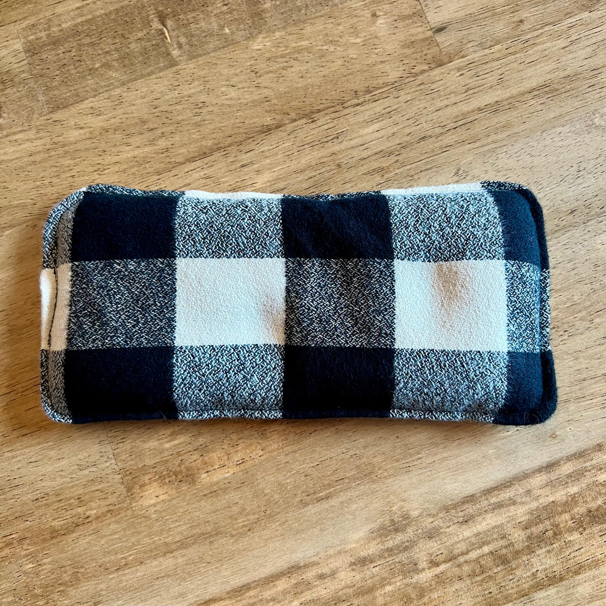 Dual-sided Nordic Check Weighted Eye Pillow by Eclectic Spruce. This pillow features a black, white, and grey buffalo plaid pattern.