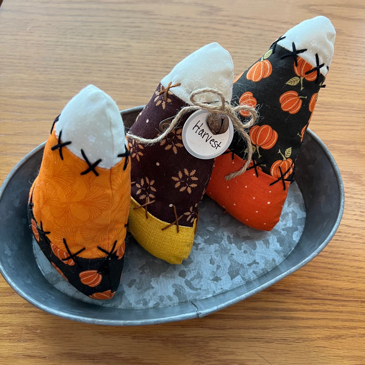 Three Eclectic Spruce handmade fabric candy corn bowl fillers with autumn harvest themes are arranged on a galvanized metal tray. 