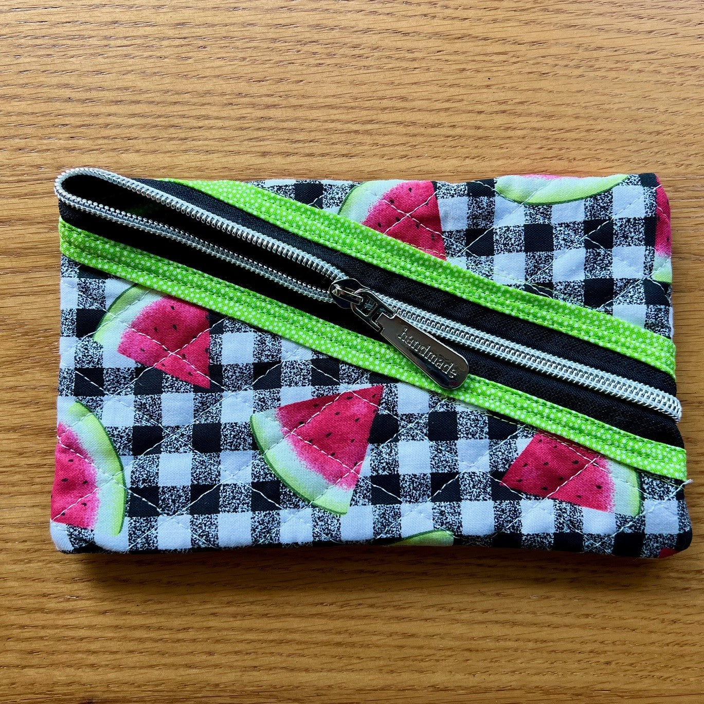 Quilted zipper pouch with landscape (horizontal) oriented zipper opening.