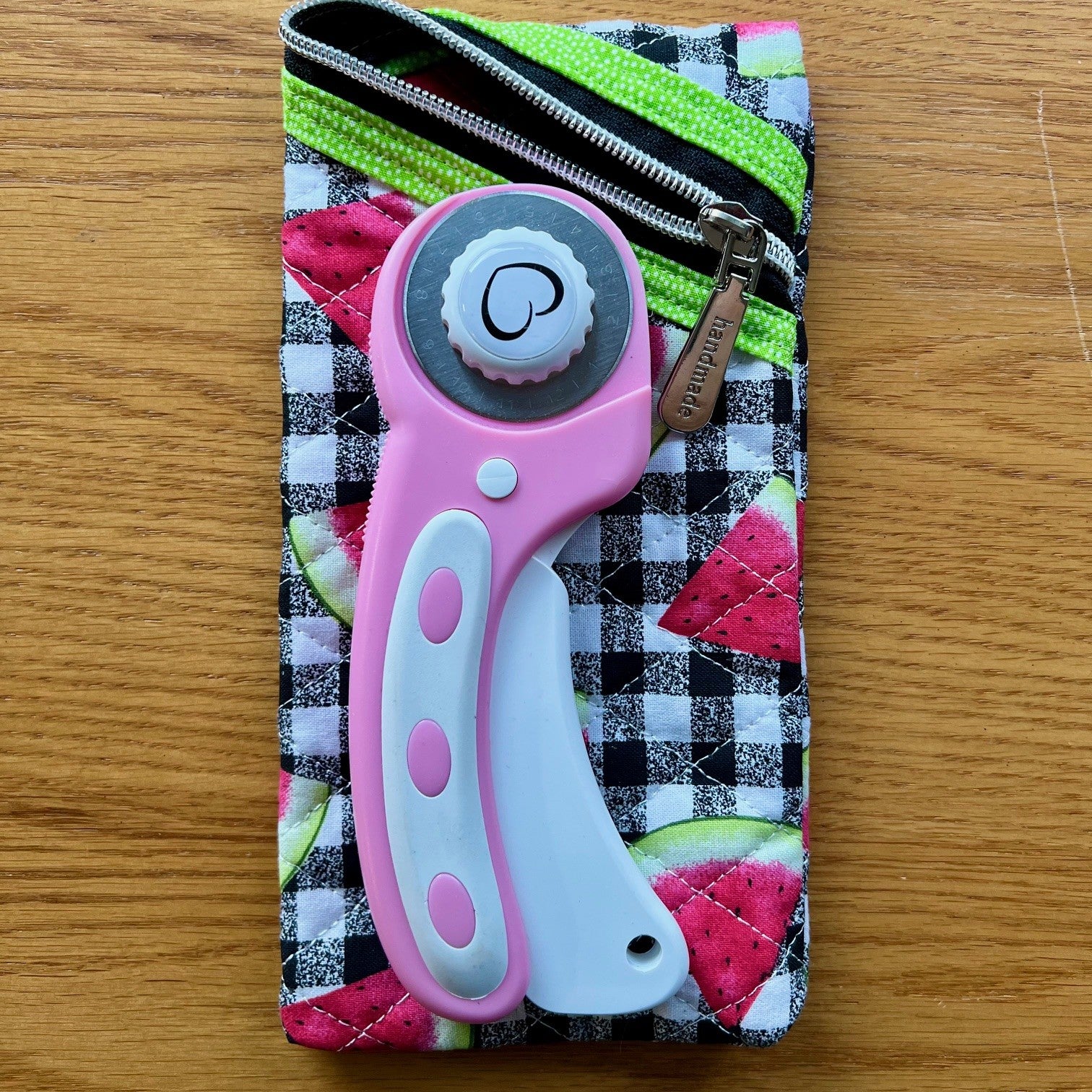 Quilted zipper pouch with a rotary cutter on top of it to show sizing.