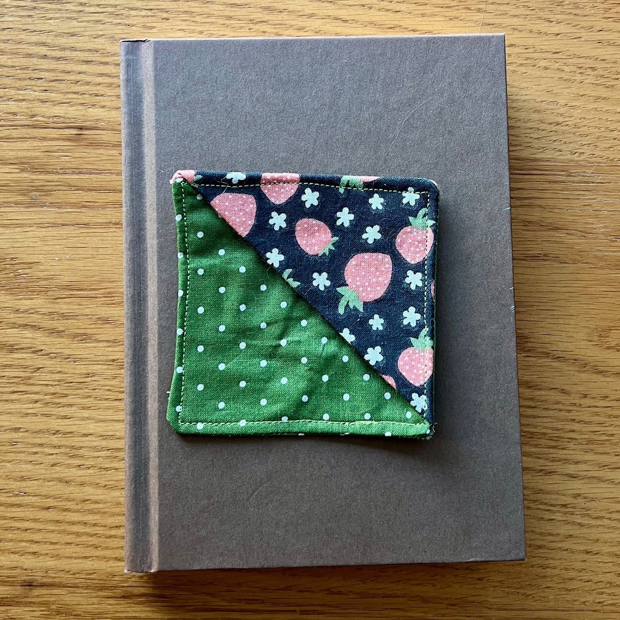 Eclectic Spruce corner bookmark sitting on top of a book.