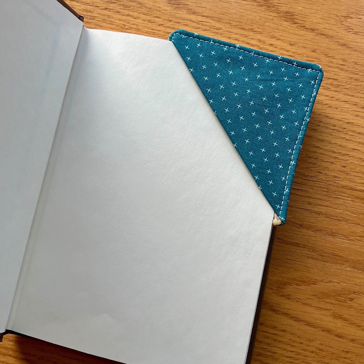 Eclectic Spruce corner bookmark placed inside of a book.