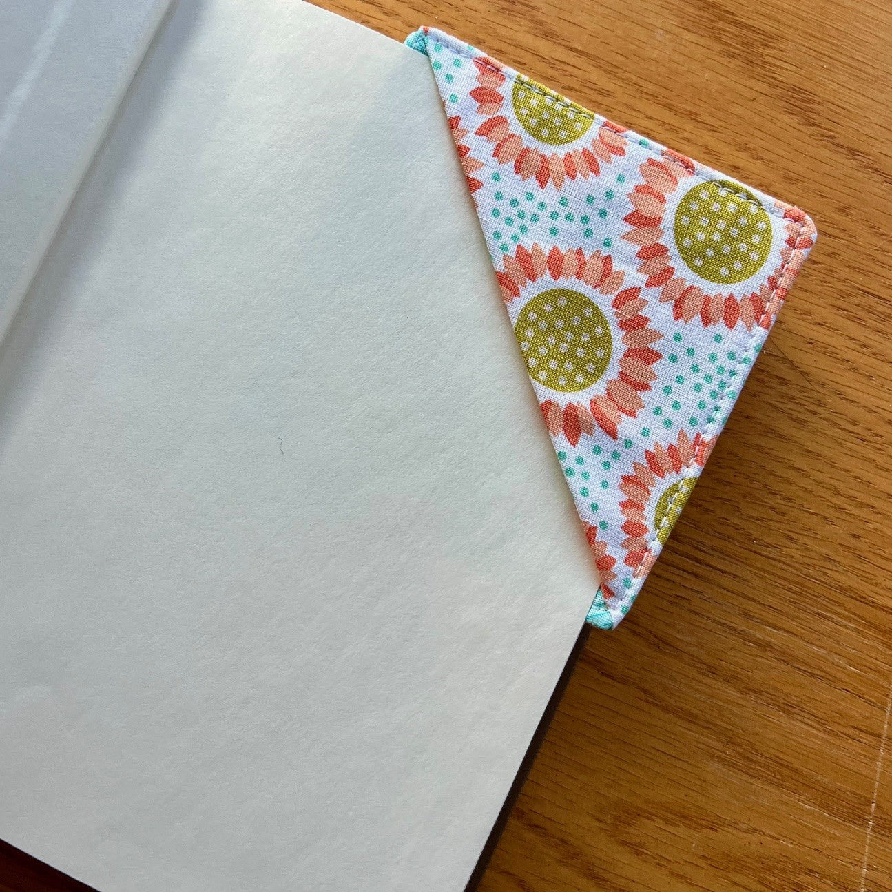 Eclectic Spruce Corner Bookmark placed inside of a book.