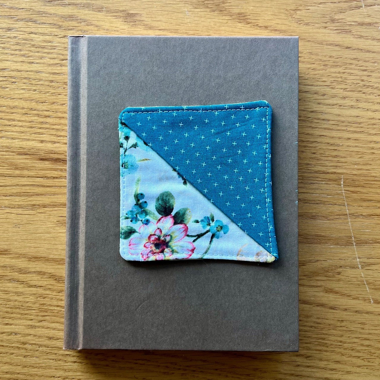 Eclectic Spruce corner bookmark sitting on top of a book.