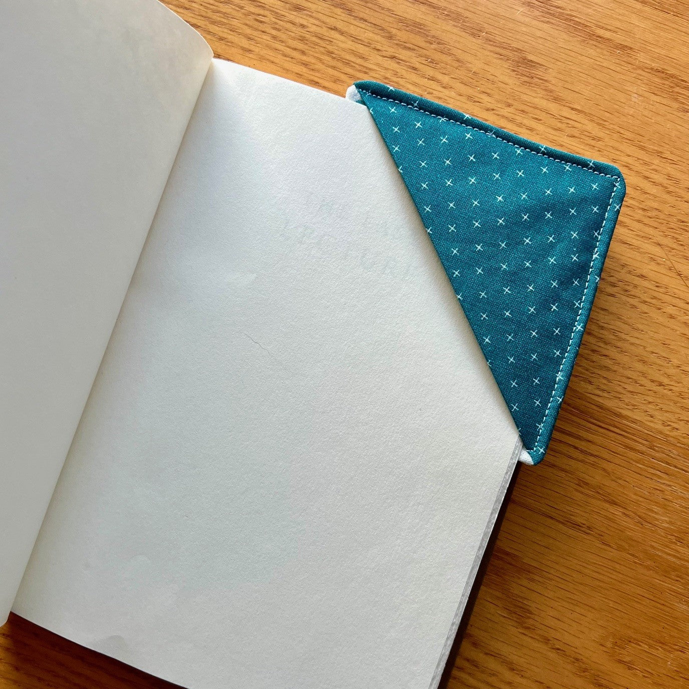 Eclectic Spruce corner bookmark placed inside of a book.