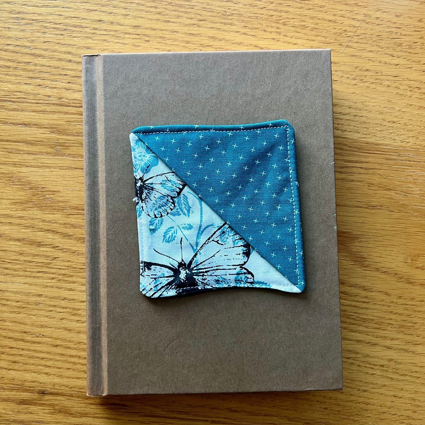 Eclectic Spruce corner bookmark sitting on top of a book.