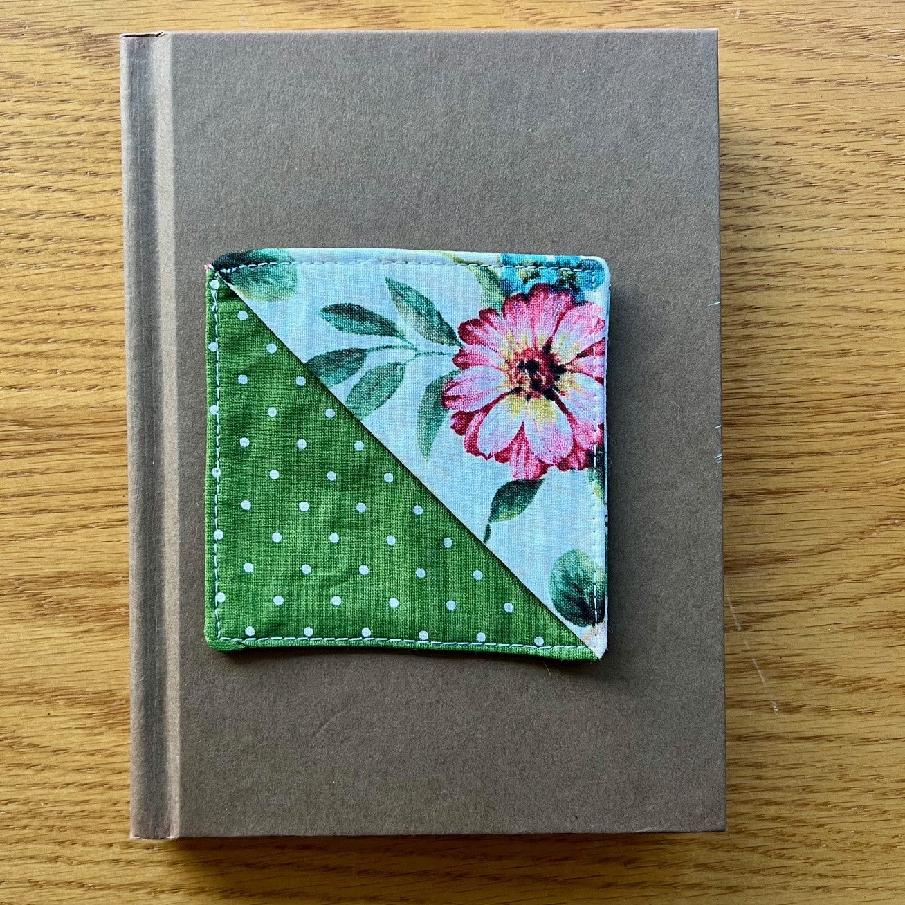 Eclectic Spruce corner bookmark sitting on top of a book.