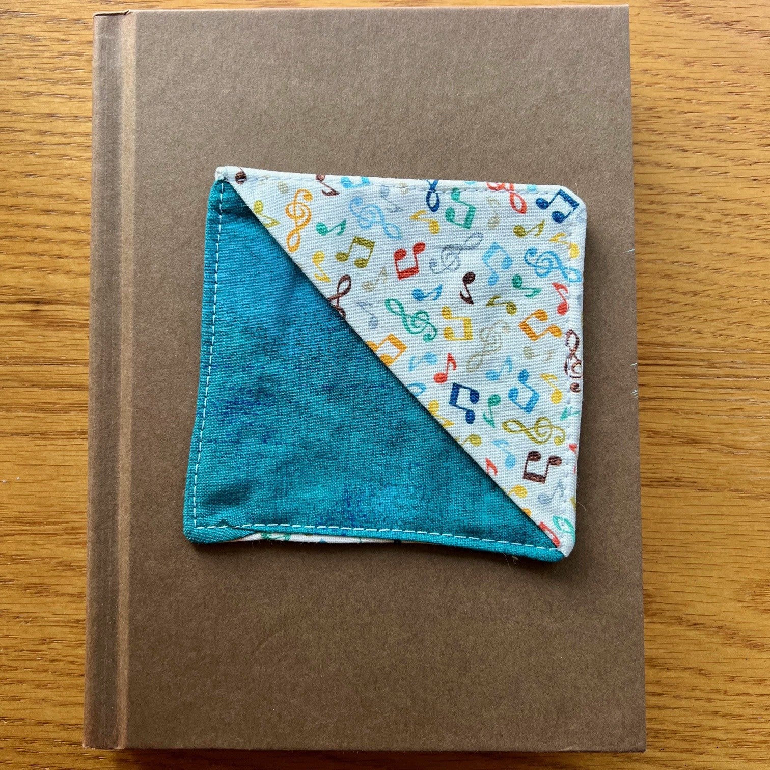Eclectic Spruce corner bookmark sitting on top of a book.