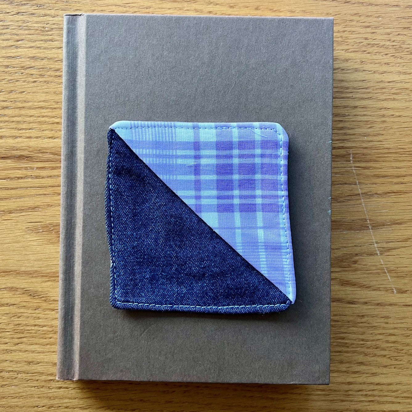 Eclectic Spruce corner bookmark sitting on top of a book.